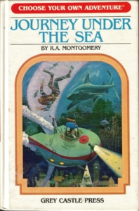 Okładka gry paragrafowej "Journey under the sea" z serii "Choose your own adventure". Przedstawia łódź podwodną płynącą nad zatopionym miastem, tonącego człowieka i płynące w jego stronę dwa rekiny.
